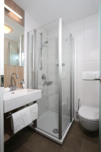 a bathroom with a shower and a sink and a toilet at Hotel-Restaurant Vogthof in Aalen