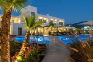 a resort with a swimming pool at night at ONEIRO Boutique Hotel in Tigaki +6 photos