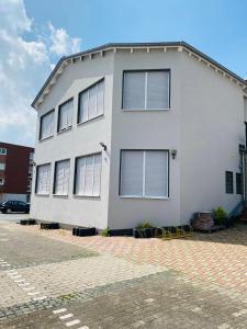 a white house with many windows on a street at Casino Hotel Hamm in Hamm