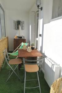 einen Tisch und Stühle auf einem Balkon mit grünem Teppich in der Unterkunft Appartement cosy Roscoff 50 m plage thalasso WIFI PARKING in Roscoff