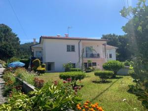 a small white house with a yard with flowers at AFIFE "Porta da Alegria" in Viana do Castelo