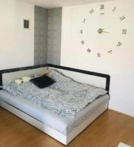 1 dormitorio con 1 cama con reloj en la pared en Bajcsy Lak en Siófok