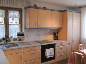 a kitchen with wooden cabinets and a sink at Haus Moderegger in Bischofswiesen