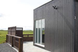 una casa nera con balcone e porta in vetro. di Strýta Apartment 3 a Ölfus Altre 19 foto