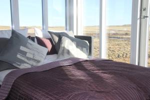 un letto con cuscini di fronte a una finestra di Strýta Apartment 3 a Ölfus