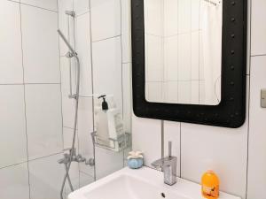 a bathroom with a sink and a shower with a mirror at Chanmou-Chair in Tainan