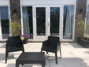 two black chairs and a bench in front of a building at BnB Purmerland in Purmerend +17 photos