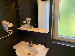 a bathroom with a sink and a mirror at Hotel Elu Iris in Split