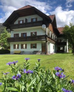 Kirchbach的住宿－舒斯特爾旅館，一座大房子前面有紫色的鲜花