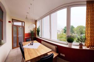 ein Esszimmer mit einem Tisch und einem großen Fenster in der Unterkunft Luxus Ferienwohnung mit hochwertiger Ausstattung Wintergarten in Cottbus