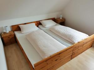 2 camas en una habitación con sábanas y almohadas blancas en Kleine Krabbe, en Büsum
