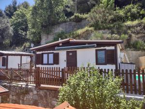 a small house with a wooden fence in front of it at Bungalow Sixdays 3 in Camporosso