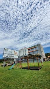 a building with a playground under a cloudy sky at Vu-Dent Apartments in Gevgelija