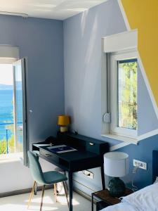 a bedroom with a desk and a bed with a window at Hotel Elu Iris in Split