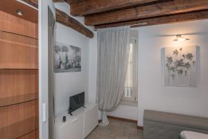 a living room with a tv and a window at San Bernardino 8 - Immobili e Soluzioni Rent in Bergamo