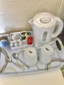 a tea pot and cups and spoons on a shelf at Claydens in Cleethorpes