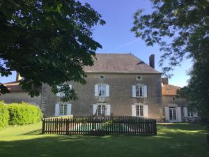 an old brick house with a wooden fence at Le Logis de Limalonges in Limalonges