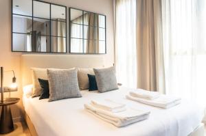 a bedroom with a white bed with towels on it at Valencia Luxury - Sea Port I in Valencia