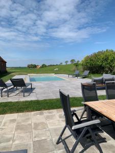 a patio with chairs and a table and a pool at Villa Baldringe in Ystad