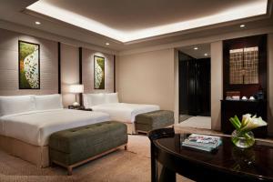 成都市にあるフェアモント チェンドゥのベッド2台とデスクが備わるホテルルームです。