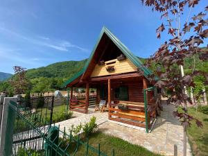 a small cabin with a green roof and a fence at STARA PRUGA JAZ in Višegrad
