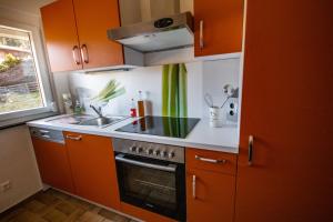 a kitchen with orange cabinets and a stove top oven at Almhaus Frierss in Verditz