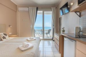 a bedroom with a bed and a view of the ocean at Galini Beach Studios and Penthouse in Mesongi