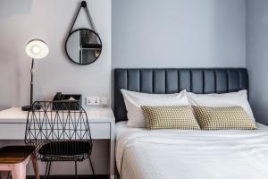 a bedroom with a bed with a desk and a mirror at Heritage Collection on Clarke Quay - A Digital Hotel in Singapore