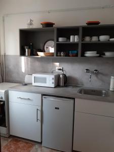 a kitchen with a sink and a microwave at Sirokkó Apartman in Balatonfüred +5 photos