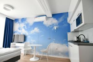 a bedroom with a blue wall with clouds painted on it at Blue Sky Apartments Rezydencja Niechorze - 301 in Niechorze