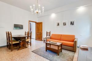 sala de estar con sofá naranja y mesa en The Country in the City - Parco delle Cascine Apartments, en Florencia