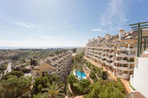 widok na budynek z basenem i palmami w obiekcie Señorío de Aloha Apartahotel w Marbelli
