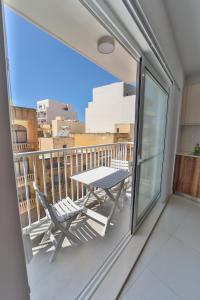 a balcony with a table and chairs on a balcony at Apartment 5 Ashville Court in Marsalforn