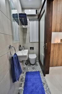 a bathroom with a toilet and a blue rug at Apartment 5 Ashville Court in Marsalforn