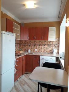 a kitchen with a white refrigerator and a table at Saules 73 in Daugavpils