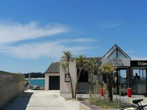 a building with palm trees in front of the water at Appartement cosy Roscoff 50 m plage thalasso WIFI PARKING in Roscoff +15 photos