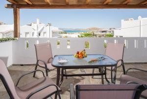 a table with a bowl of fruit on a patio at Aqua Naxos Apartments & Suites in Naxos Chora