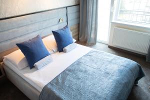 a bed with two blue pillows in a bedroom at Dom Wypoczynkowy Małgosia in Władysławowo