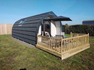 a black and white tiny house with an umbrella at Glamping Pods in Cromer