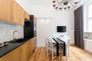 - une cuisine avec une table, des chaises et un évier dans l'établissement Apartament na Gdańskiej Starówce, à Gdańsk