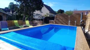 una piscina con agua azul en un patio trasero en Gîtelabaronnaise avec piscine chauffée prés parc Asterix, en Baron
