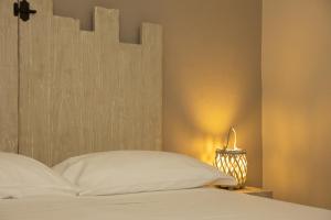 a white bed with a wooden headboard and a lamp at Vecchio Granaio in Pisa
