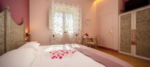 a bedroom with a white bed with flowers on it at Vecchio Granaio in Pisa