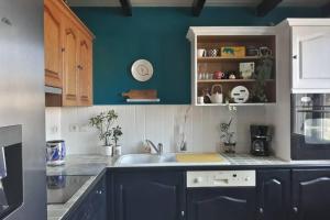 a kitchen with a sink and a blue wall at Villa 3 étoiles près des plages, Parking, Wifi, Clim in Sauvian