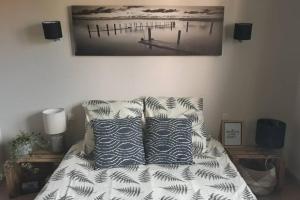 - un lit avec deux oreillers et une photo de jetée dans l'établissement Villa 3 étoiles près des plages, Parking, Wifi, Clim, à Sauvian