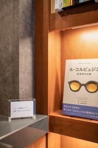 un par de gafas en un estante junto a una caja en hotel aima, en Tokio