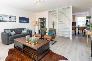 ein Wohnzimmer mit Sofa und Tisch in der Unterkunft Grasse 148 - Kustpark Village Scaldia in Hoofdplaat