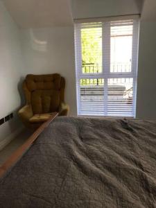 a bedroom with a bed and a chair and a window at York - The Burton Stone - with parking in York