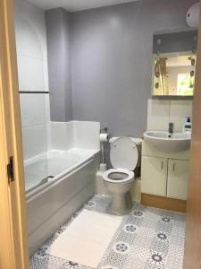 a bathroom with a toilet and a tub and a sink at York - The Burton Stone - with parking in York
