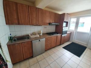 a small kitchen with wooden cabinets and a sink at Dovolenkový dom Green House in Lom nad Rimavicou